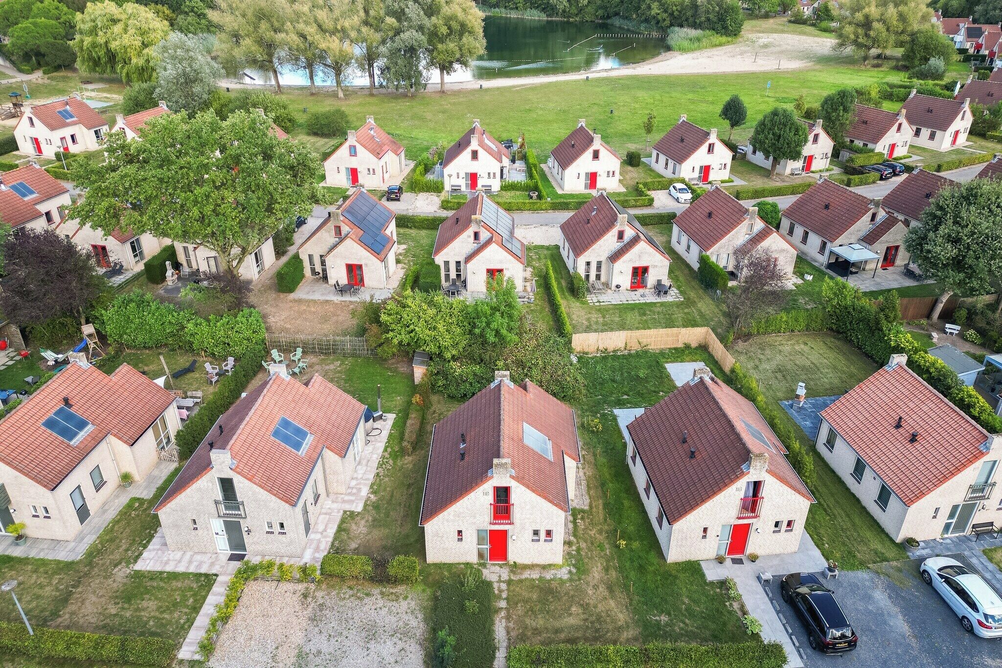 Ein Wohngebiet mit einheitlichen Häusern, roten Türen und Solaranlagen.