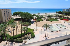 A beachfront hotel with a pool area, palm trees, and a view of the ocean. - UHC CASPEL - The best rooftop terrace in La Pineda (La Pineda)