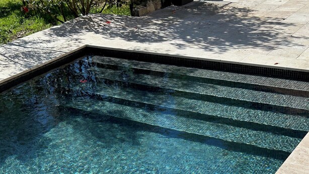 A clear swimming pool with tiled steps leading into it. - Sunset by FY (Josse)