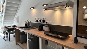A modern kitchen with a wooden countertop, built-in oven, and a black dishwasher. - Sunset by FY (Josse)