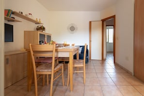 Un coin repas avec une table et des chaises en bois, un buffet et un élément décoratif fixé au mur.