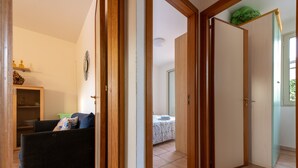 Een kamer met een bed, een houten garderobe en een bank.