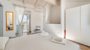 A bedroom with a large bed, a mirror, a chair, and a wardrobe. - Holiday Home 'La Casetta' with Private Terrace, Wi-Fi and Air Conditioning (Giba)