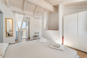 Un dormitorio con una cama grande, un espejo, una silla y un armario.