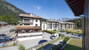 A hotel with multiple floors, outdoor seating, and a parking area with cars.