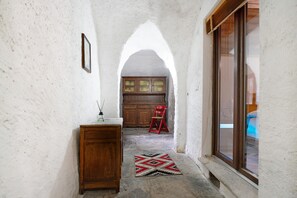 A narrow hallway with a wooden cabinet, a red chair, and a patterned rug. - Apartment "Casa del Sole" with Mountain View & Wi-Fi (Toceno)