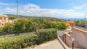 A residential area with a street, greenery, and buildings in the background. - Holiday Home 'Casa Erbì' with Sea View, Private Terrace and Private Garden (Torre dei Corsari Arbus)