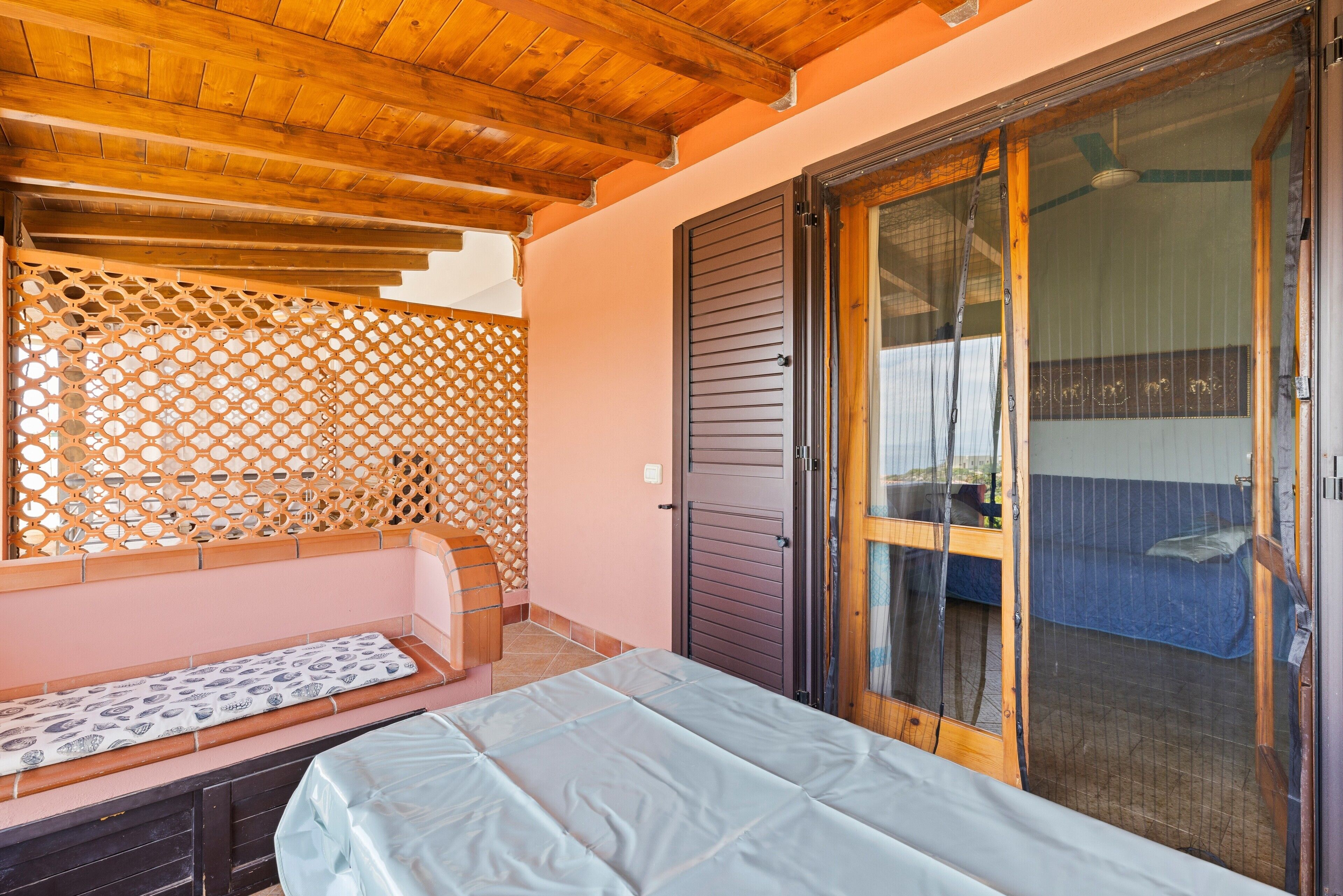 Une pièce avec un lit, un plafond en bois, une porte coulissante et une vue à travers la porte.