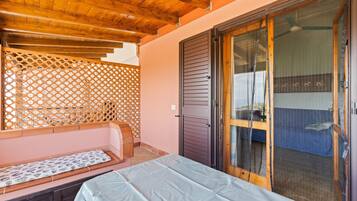 Une pièce avec un lit, un plafond en bois, une porte coulissante et une vue à travers la porte.