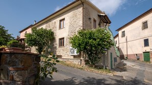 A stone building with a flat roof, a small window, and a green door. - Apartment "La Sosta del Pellegrino" with Mountain View, Private Garden & Wi-Fi (Sorano)