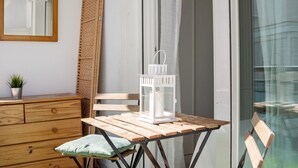 A wooden table with a white lantern, a green cushion, and a wooden bench.