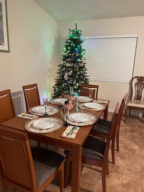 Enjoy meals with family and friends at this dining area, featuring a table for four, comfortable chairs, and a stylish centerpiece.
