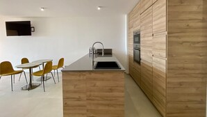 Une cuisine moderne dotée d’un îlot central, de meubles en bois et d’un coin repas avec des chaises jaunes.