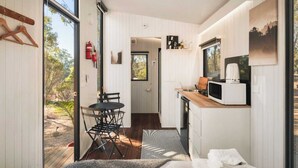 Una cocina compacta con comedor, microondas y un ventanal.