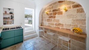 Eine Küche mit einer Steinwand, einer Bar und einer Obstschale.