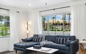 A modern living room with a sectional sofa, a coffee table, and a floor lamp. - Sun Devil Paradise! 3BR Butler House - Walk to ASU, Mill Ave & Town Lake (tempe)
