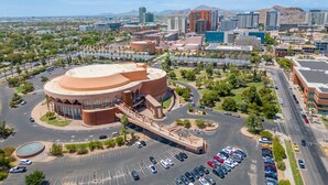 Un edifici gran i circular amb un pati central, envoltat de places d'aparcament i carreteres.