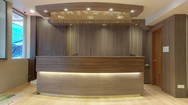 Una recepción de diseño moderno, con acabado de madera e iluminación integrada.
