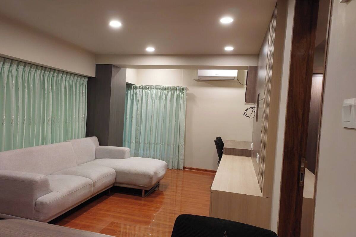 A living room with a sofa, a small table, and a door leading to another room.