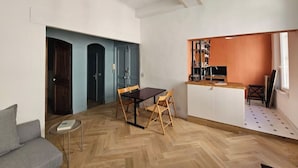 Un espacio habitable compacto con comedor, kitchenette y sofá.