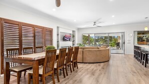 Un comedor moderno con mobiliario de madera, un ventanal y vistas al exterior.