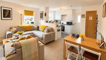 A modern apartment with a living room, dining area, and kitchen.