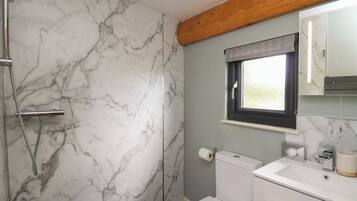 A bathroom with a shower, toilet, and sink.