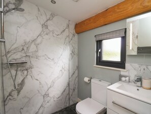A bathroom with a shower, toilet, and sink.