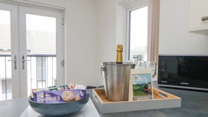 Eine Küchenarbeitsplatte mit einer Schüssel Kekse, einer Champagnerflasche und einer Karte.