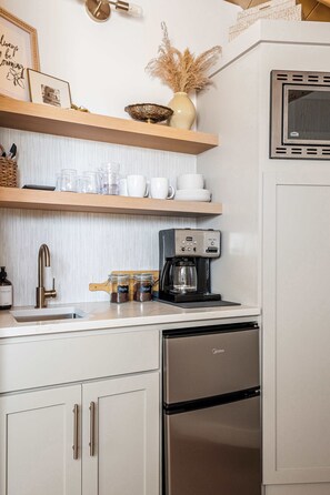 Frigorífico, microondas, cafetera o tetera y utensilios de cocina