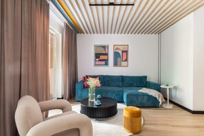 Wide-angle view of the living space, combining a dining area, teal furniture, and modern aesthetics.