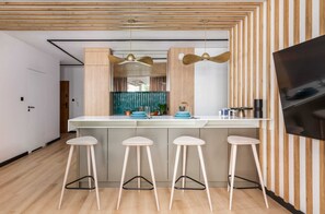 Kitchen and dining space with a cohesive modern design and bold teal accents.