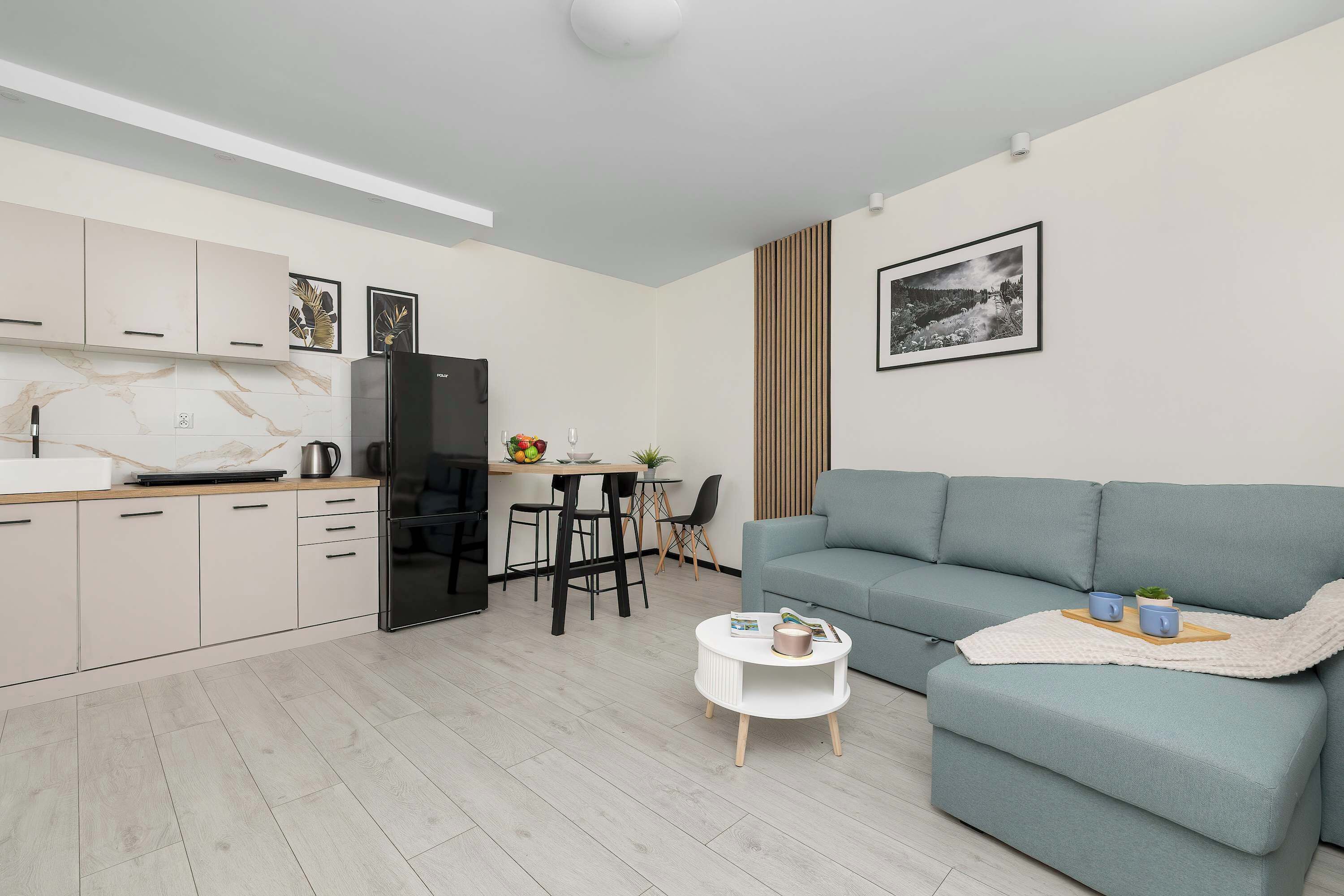 A modern apartment with a kitchen, dining area, and living room.