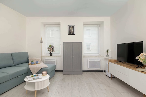 A living room with a sofa, a coffee table, a TV, and a cabinet.