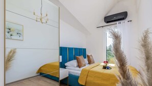 A modern bedroom with a mirrored wardrobe, a blue headboard, and a yellow bedspread. - Stylish Apartment | Parking, Balcony, Close to the Beach (Sianozety)