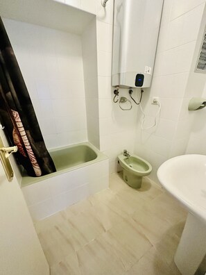 Un baño con bañera, bidé y lavabo.