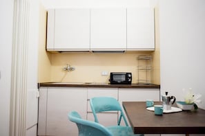 A compact kitchenette with a built-in microwave, a small sink, and a cup holder.