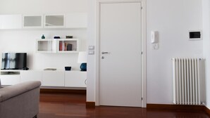 A modern living room with a flat-screen TV, a sofa, a white door, and a radiator. - Marechiare Intera in Ortona (Ortona)