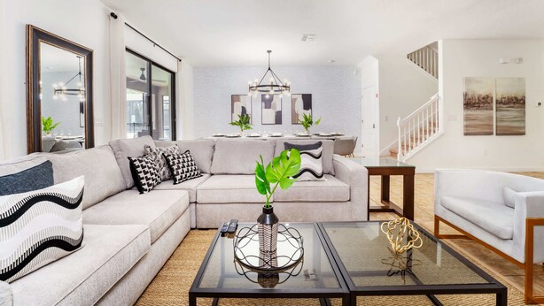 Un salon moderne avec un canapé, une table basse et un escalier en arrière-plan.