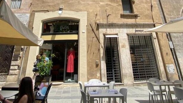 Un edificio storico con diverse finestre e un ingresso centrale.