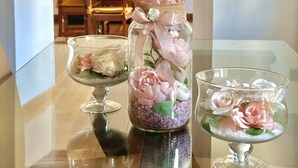 Un tavolo da pranzo con bicchieri, fiori, una sedia di legno e un trave rustico a soffitto.