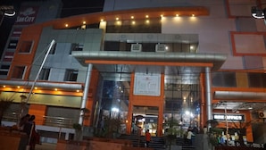 A multi-story hotel with a prominent 'Sun City' sign, a glass facade, and a modern architectural design. - Hotel Suncity  (Hisar)