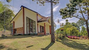 A modern house with a large glass window, a brick facade, and a well-maintained lawn. - Hotel O Villa Inn App Trawas Bintaro Syariah (Trawas)