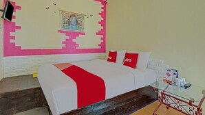 A hotel room with a bed, a glass table, and a window with a curtain. - Hotel O Villa Inn App Trawas Bintaro Syariah (Trawas)