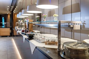 A buffet setup with various food items and utensils, including bowls, plates, and a coffee machine. - Thermenhotel Gesundheits-Bad Buchau (Bad Buchau)