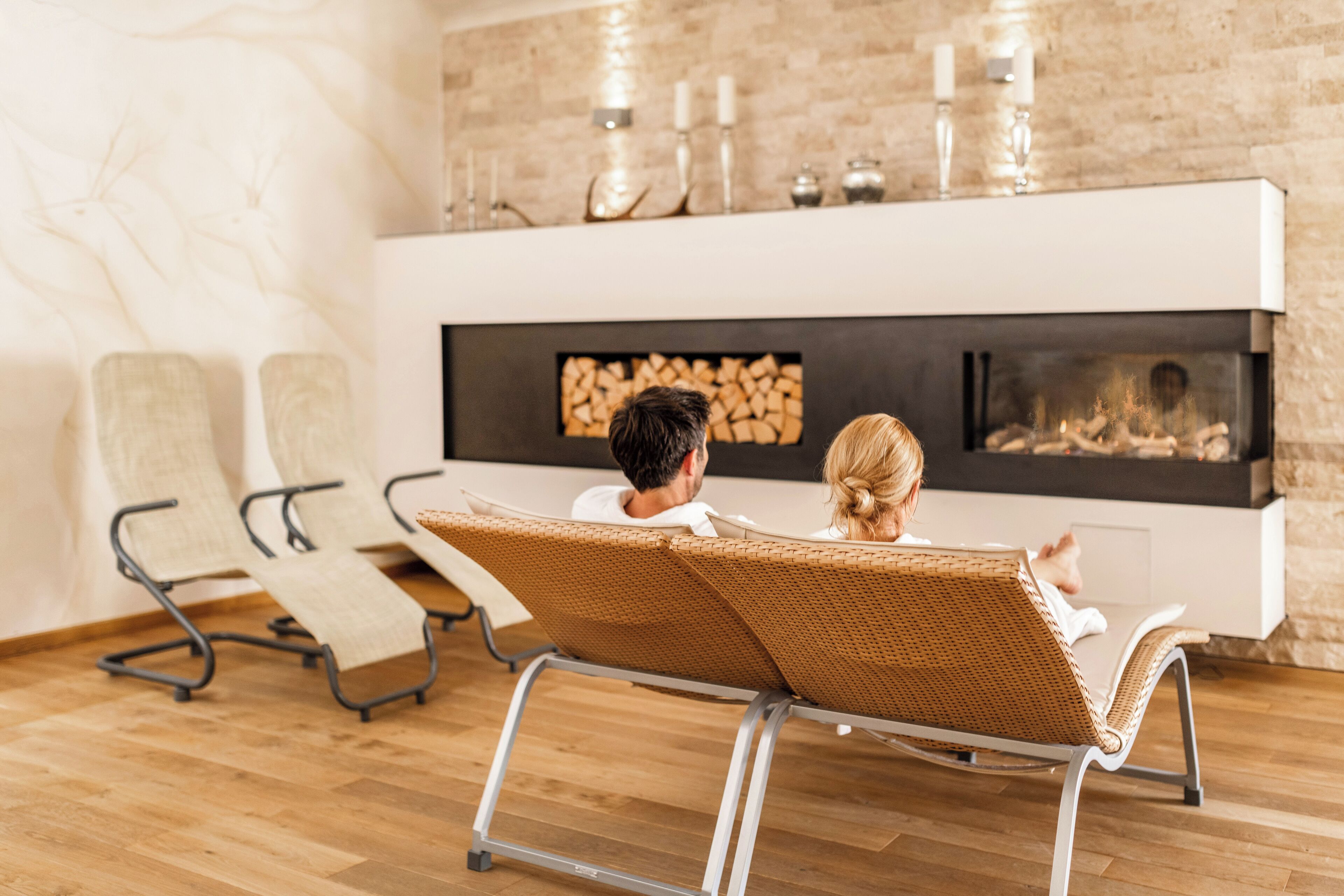 Ein modernes Wohnzimmer mit Kamin, zwei Sesseln und einer Ziegelwand.