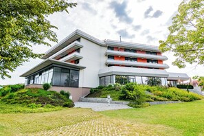 A modern multi-story building with a flat roof, large windows, and a landscaped garden. - Thermenhotel Gesundheits-Bad Buchau (Bad Buchau)