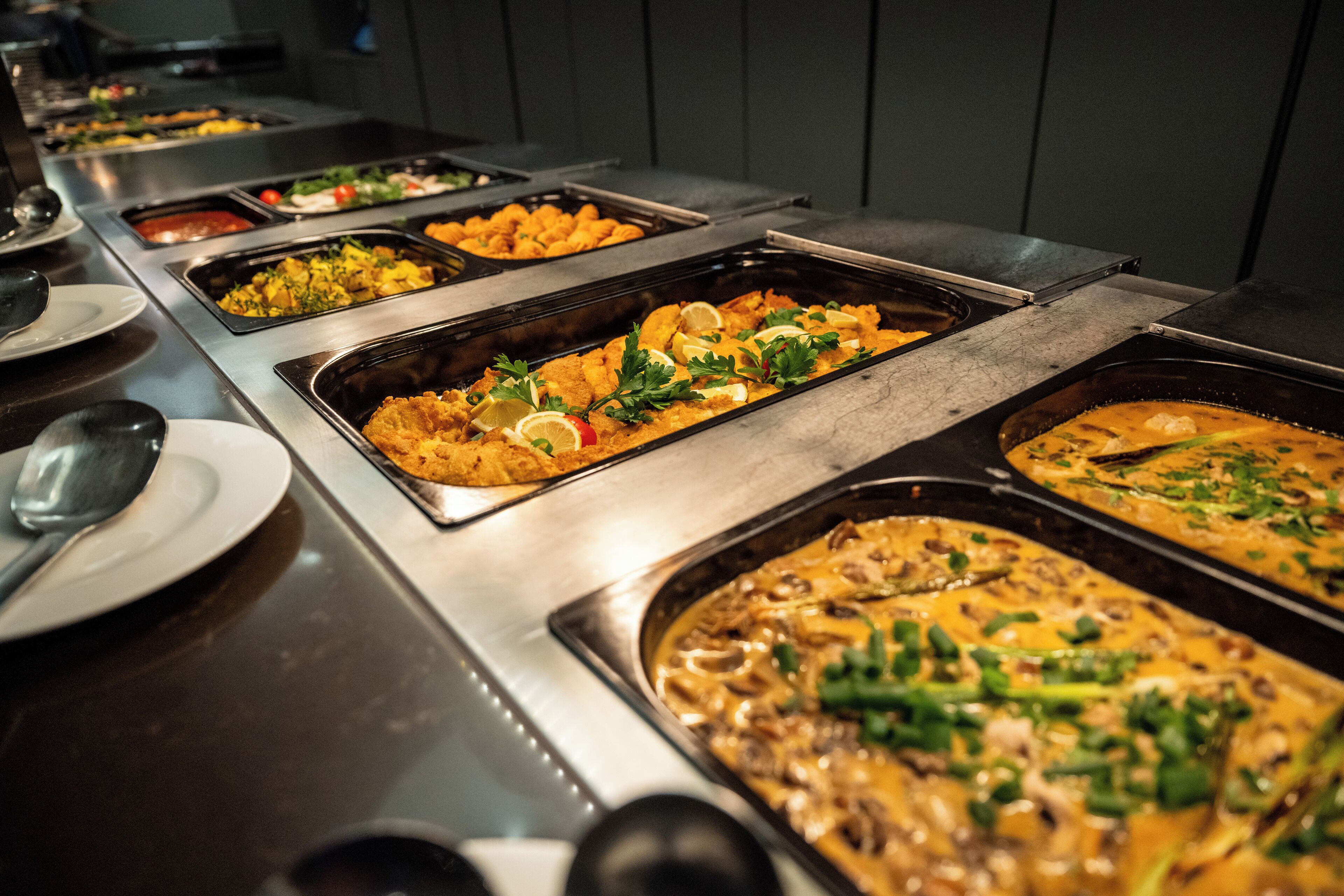 A buffet with various dishes, including seafood, salads, and a casserole.