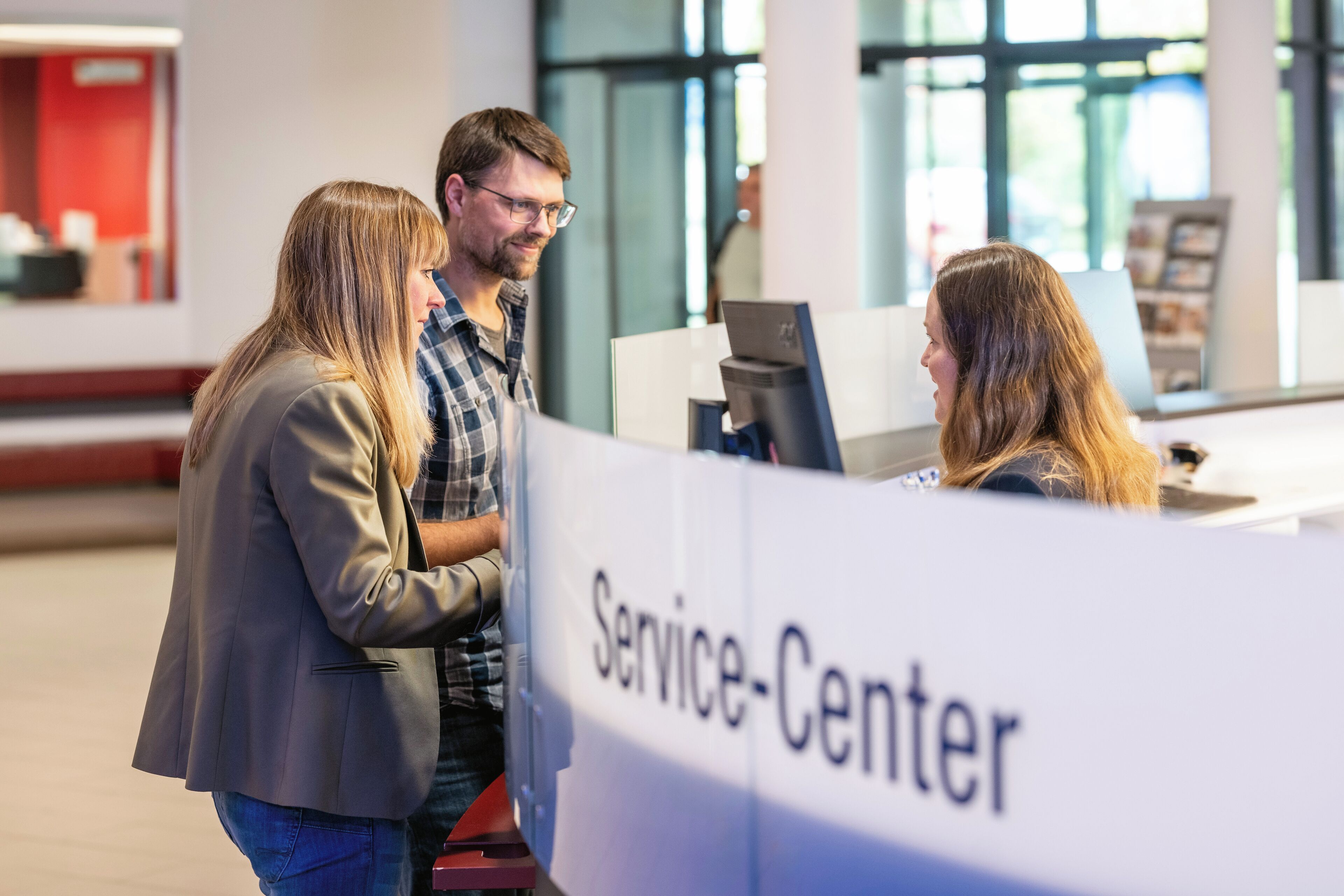 A group of people at a service center with a sign that reads "Service-Center".