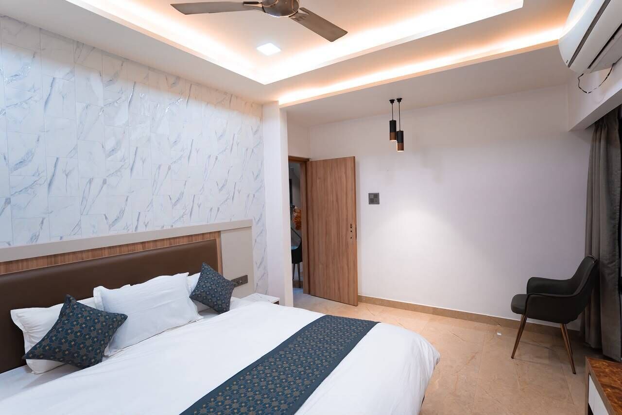 Una camera d'albergo moderna con un letto grande, una ventola a soffitto e un condizionatore d'aria.